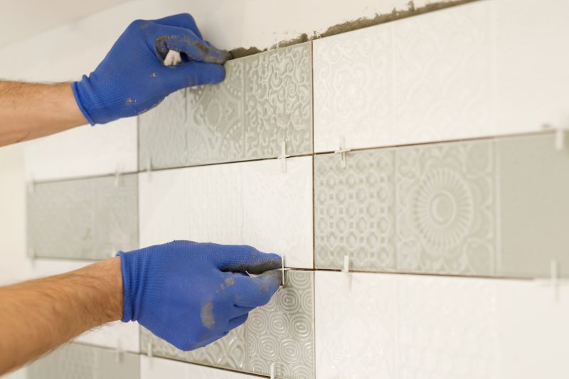A professional tile installer working on a shower